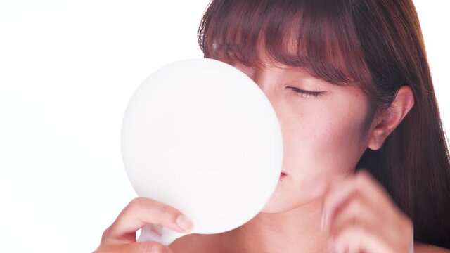 鏡で目を見る女性