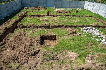 Digged  foundation for a house. Building site with concrete fence