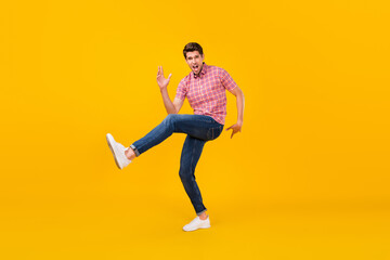 Fototapeta na wymiar Full size photo of happy cheerful crazy man dance funky raise leg funny isolated on yellow color background