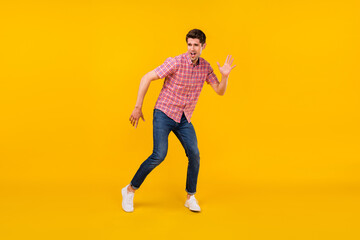 Naklejka na ściany i meble Full length photo of happy positive cheerful man look empty space dance isolated on yellow color background