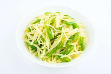 Shredded potatoes with green pepper on a saucer on white background