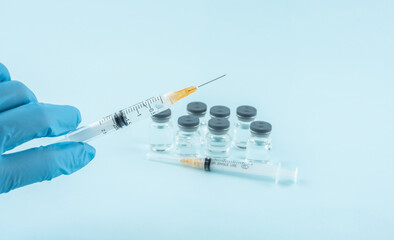 Doctor holding vaccine medicament and syringe in hand