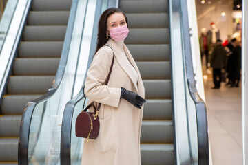 middle aged woman with gloves and mask on escalator in public place