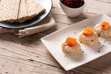 Traditional Jewish gefilte fish with beetroot and matzah bread on wooden table