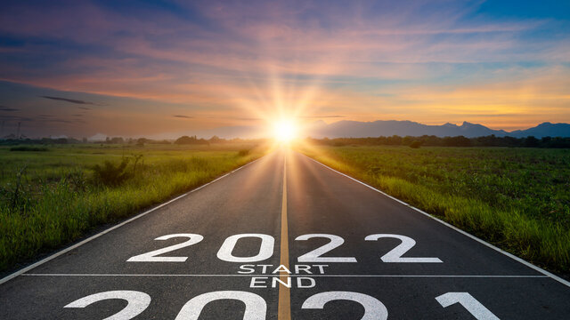New year 2022 or start straight concept.word 2022 and strategy written on the road of asphalt road at sunset.Concept of target and challenge or career path,success business,opportunity and change