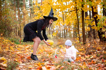 black witch with little toddler bunny in the autumn forest. halloween celebration, costume party