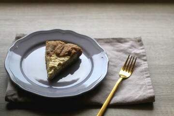 Slice of cheese and leek quiche on wooden table. Selective focus.