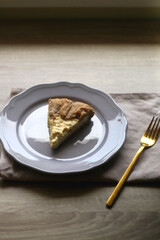 Slice of cheese and leek quiche on wooden table. Selective focus.