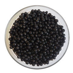 a bowl of chokeberry stands on a white background. top view
