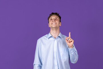Caucasian young man's portrait isolated on purple color studio background. Concept of human emotion, facial expressions, youth, feelings, ad.
