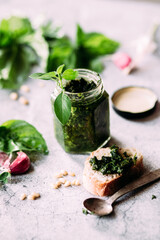 Pesto sauce in a glass jar on the table. Preparation