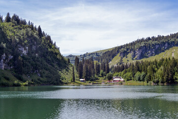 Swiss countryside. Small lake with people in the mountains in summer. Swiss Alps.