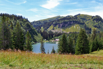 Swiss countryside. Small lake with people in the mountains in summer. Swiss Alps.