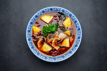 A large bowl of hot and sour pineapple boiled fish fillets