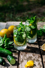 Lemonade with lemon, mint, cucumber and ice in a glass