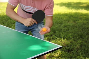 Man playing ping pong in park, closeup