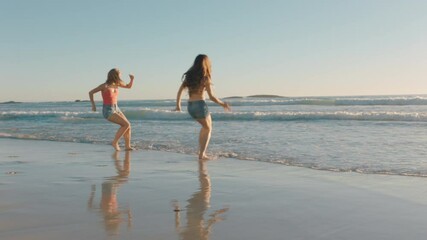 girl friends running on beach into sea splashing in water having fun playing game teenage girls enjoying warm summer day on vacation