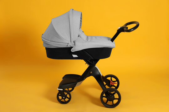 Baby carriage. Modern pram on yellow background