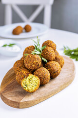 A traditional Israeli dish fresh falafel on a wooden board, garnished with a sprig of parsley. Middle Eastern cuisine