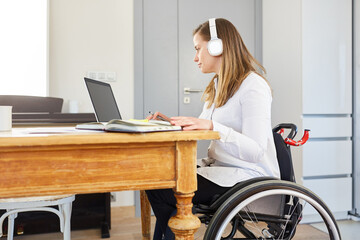 Gelähmte Studentin im Rollstuhl beim E-Learning am Computer
