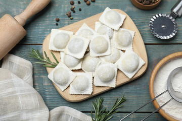 Homemade uncooked ravioli on blue wooden table, flat lay