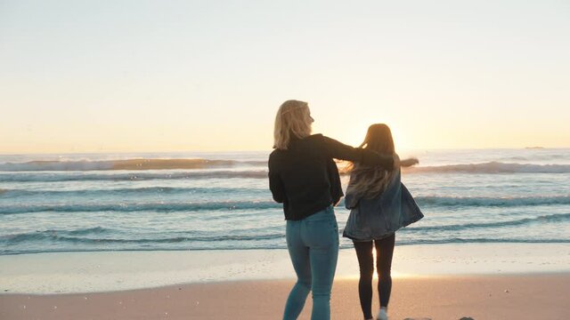 girl friends blowing bubbles on beach at sunset having fun summer playing by the sea enjoying friendship