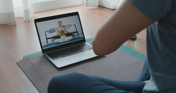 Close-up asia people woman enjoy study happy watch live video sit on sport mat at cozy home floor indoor easy zen class. Body calm life stress relax asana lotus pose in laptop self learn online media.
