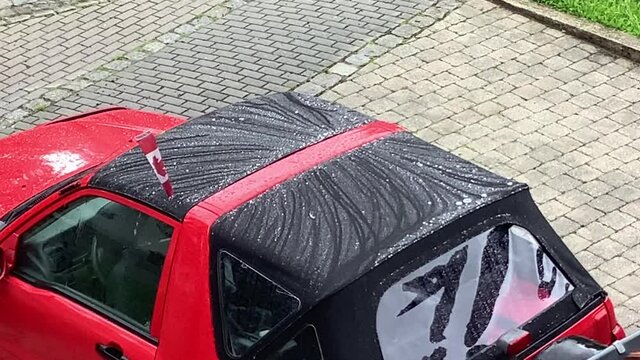 Abperlendes Regenwasser nach einer Impr&auml;gnierung auf dem Stoffverdeck eines Autos 
