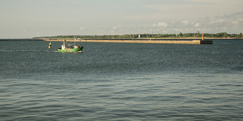 A small ship enters the port.