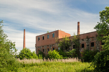 Fototapeta na wymiar Old abandoned factory with big chimneys in Pavilosta, Latvia.
