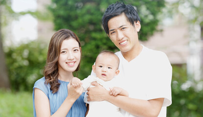 屋外で赤ちゃんをあやす両親