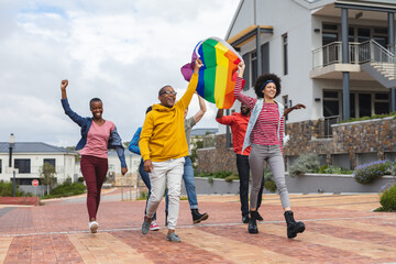 Smiling diverse group of people holding lgbt flag at protest march