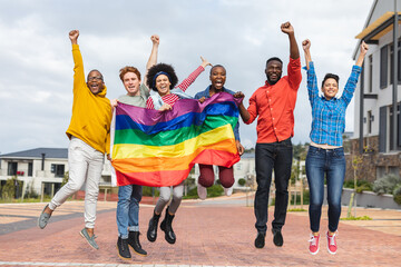 Smiling diverse group of people holding lgbt flag at protest march