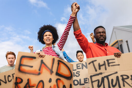 Diverse crowd of people holding placard at protest march
