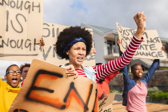 Diverse crowd of people holding placard at protest march