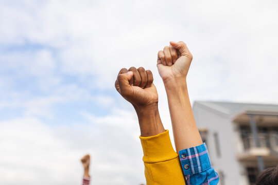 Diverse people raising their fists at a protest march