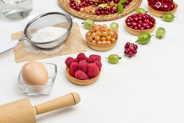 Rolling pin and egg, bottle of water. Flour in sieve.