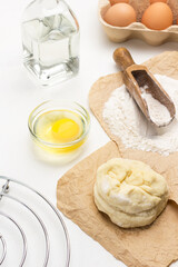 Raw dough and scoop with flour on paper.