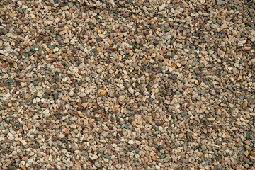 Natural colorful pebble stones background texture with copy space.