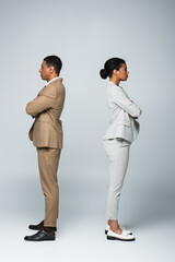 side view of african american business people standing separately with crossed arms on grey, gender equality concept