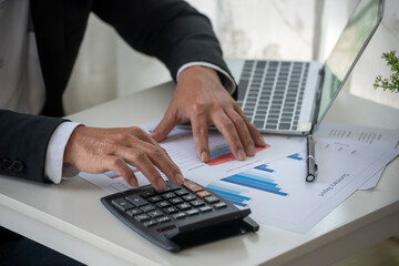 Close up Man hands calculating number, data, graph, chart audit planning accountancy on business report. Business man hands using calculator counting tax financial bill.  Tax audit Finacial concept.