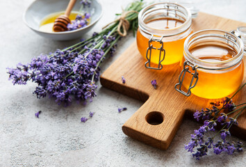 Obraz na płótnie Canvas Jars with honey and fresh lavender flowers