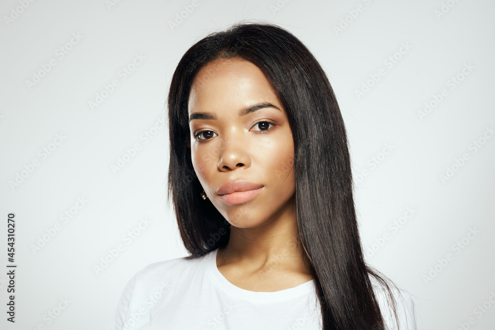 Sticker attractive woman of african appearance in a white t-shirt straightens her hair earrings