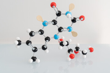 Isolated vitamin B2 made by molecular model with reflection on white background. Riboflavin chemical formula with colored atoms and bonds.