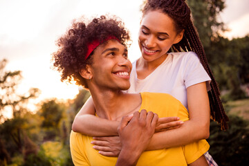 Photo portrait young couple spending time outdoors together on summer streets embracing piggyback happy