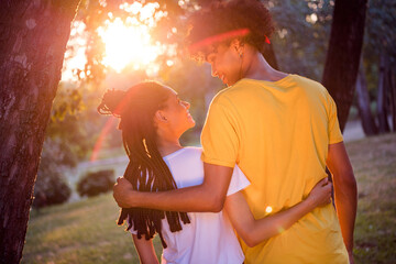 Fototapeta premium Rear back behind view portrait of attractive cheerful tender careful couple hugging looking at sun set horizon at forest outdoors