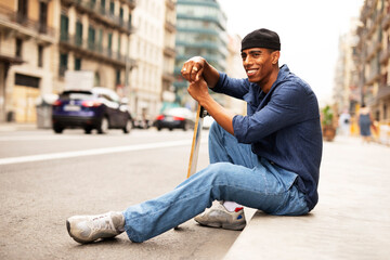 African man with skateboard. Young handsome man having fun outdoors.