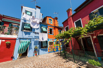 Burano island, houses with bright colors and clothes hanging on clotheslines to dry in the sun....