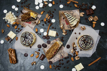 Lots of pastries and cakes, chocolate, frosting and cinnamon top view on a dark background, copy space