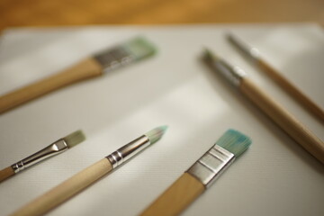 Used brushes for painting with wooden handles on white textured paper